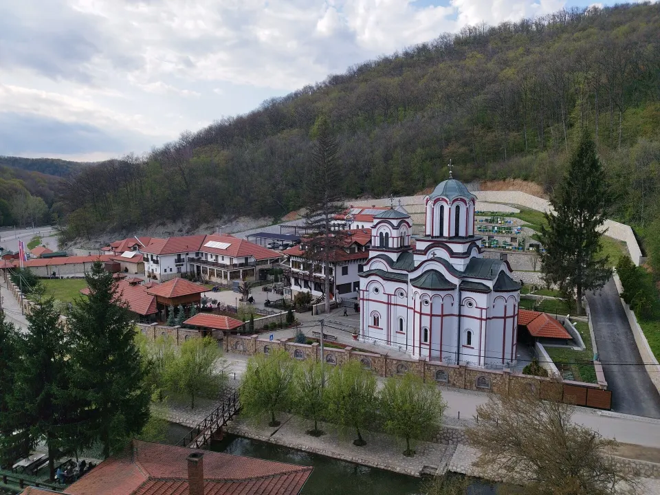 Aerial view of Tumane Monastery — the church and lodgings in a wooded valley